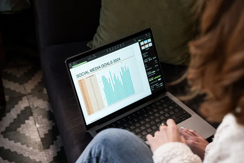 Woman reviewing social media goals and analytics on laptop at home