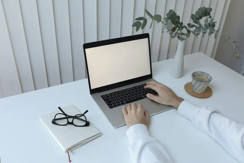 Remote worker reviewing freelance platforms at a home workspace with notepad and coffee