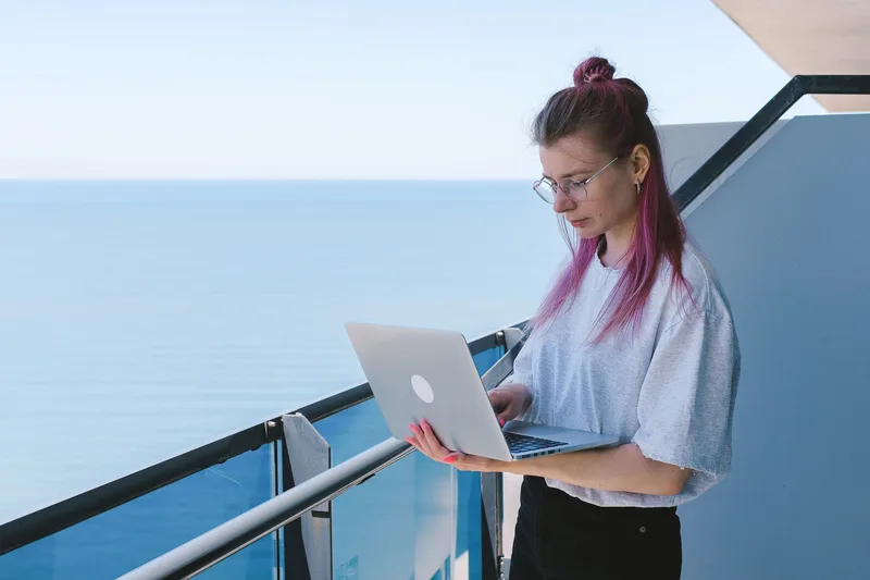 Freelancer working remotely by the water with a laptop